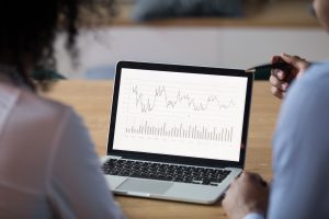 rear view at african analysts analyze financial report on laptop